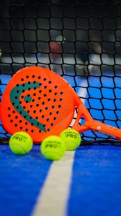 Orange Head padel racket with balls on court